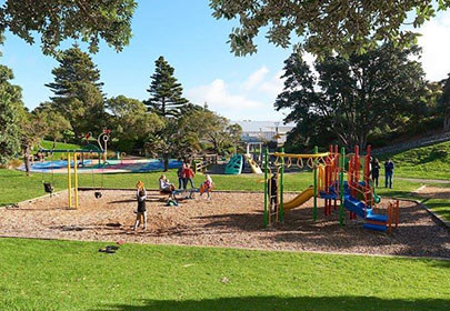 Image showing children playing on the playground at Raumati's Marine Reserve, with the splashpad in the background
