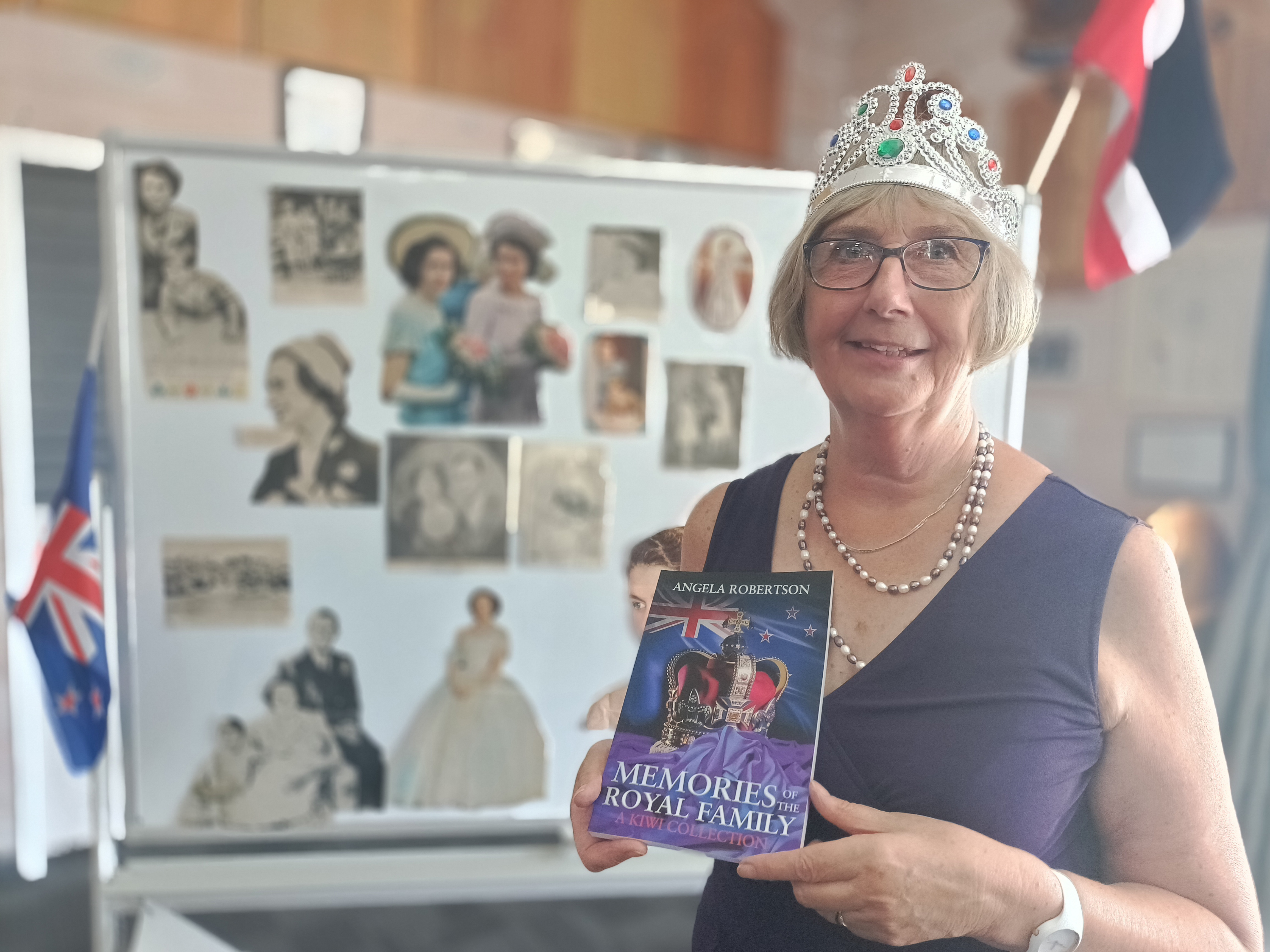 Kāpiti resident Angela Robertson wears a crown while holding hew recently published book 'Memories of the Royal Family'.