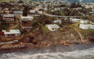 Coastal erosion behind failed structures on Rosetta Road following a significant storm in 1976.