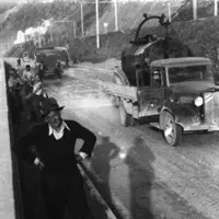 The man in the foreground is thought to be JR McLauchlan, the contractor whose truck is seen on the right. Behind him are Joe Ropata, Reg Fielding and Fred Strand putting "chips" on the road surface for Centennial Highway, 1939. HP 1091 J Beattie Collecti thumbnail