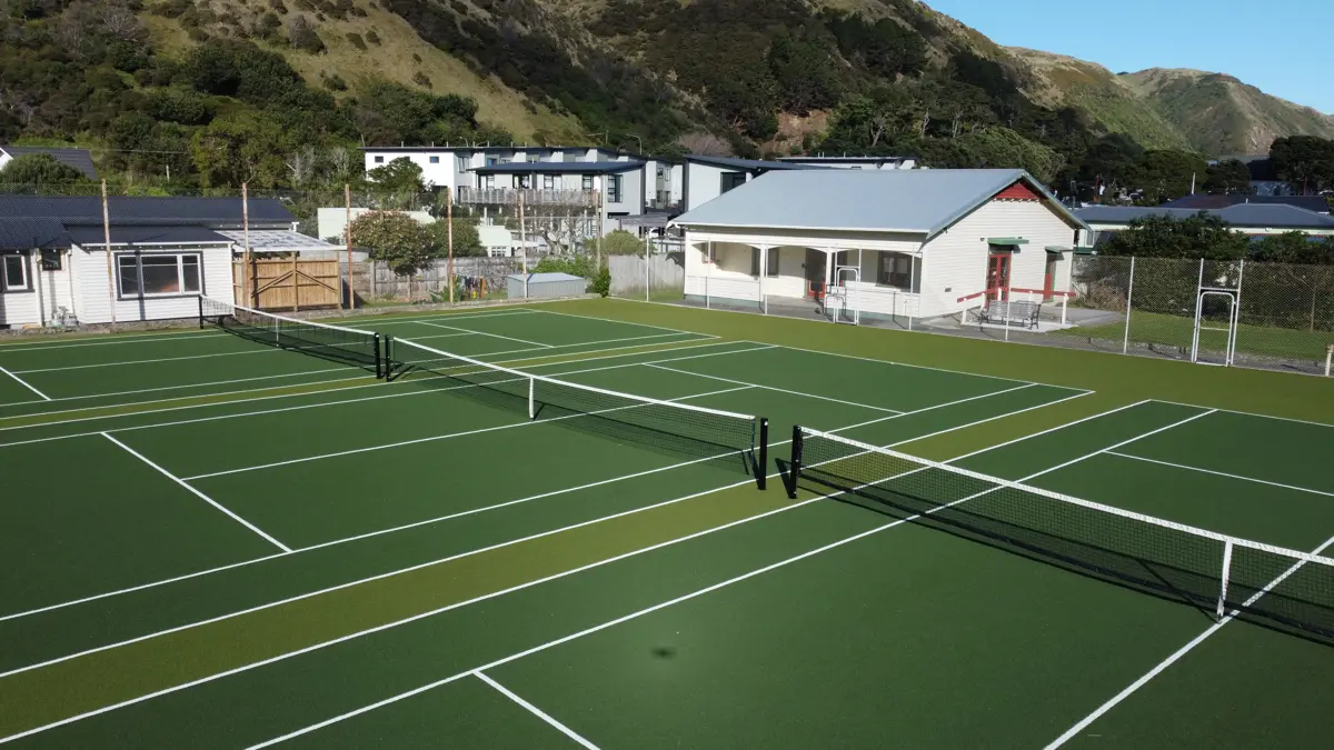 Three tennis courts with tennis club in background
