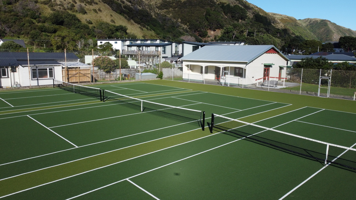 Three tennis courts with tennis club in background