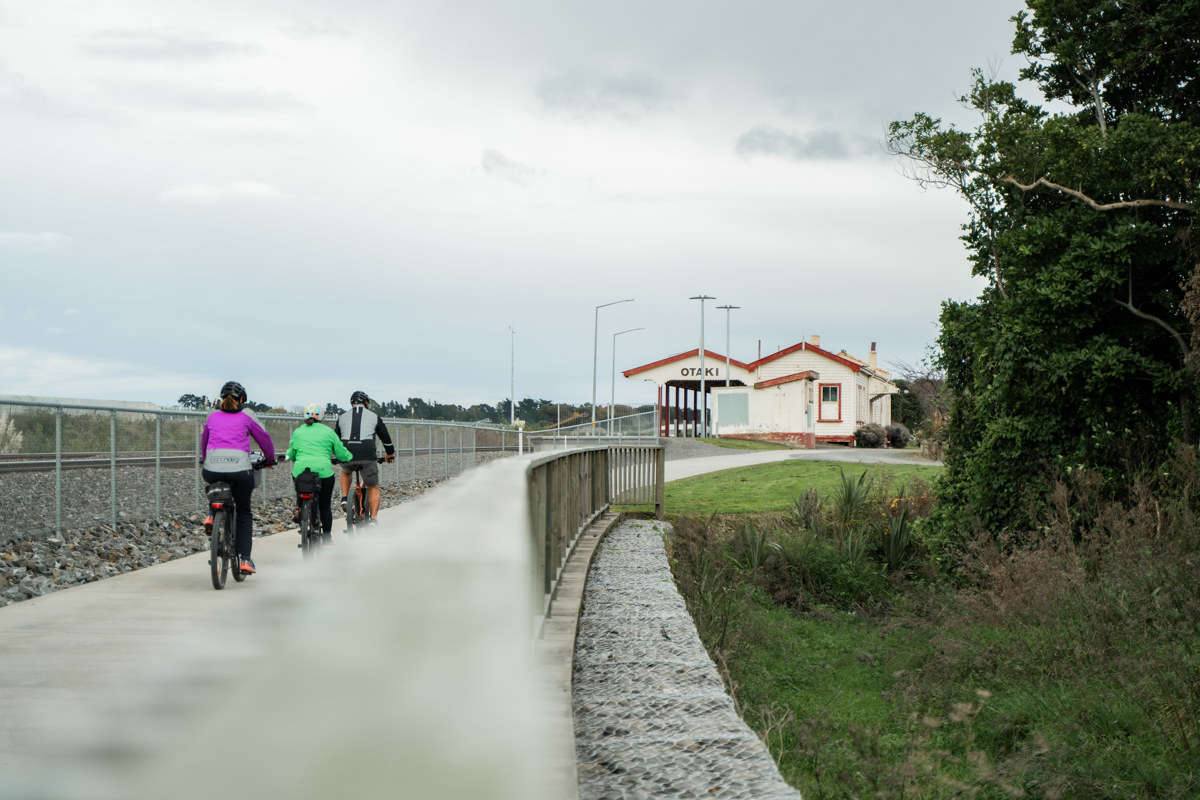Three cyclists on the bike trail heading towards Ōtaki station.