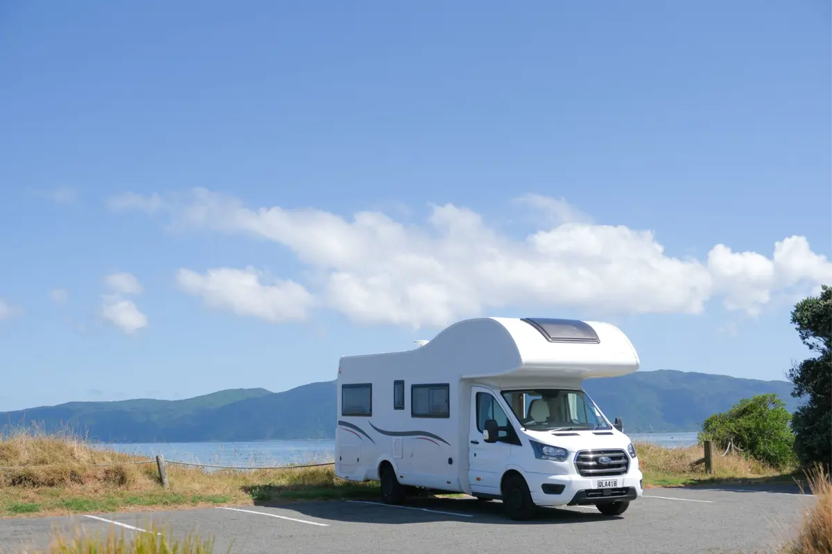 Caravan parked on concrete with Kāpiti island in the background