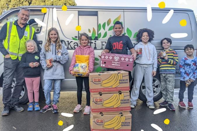 Good Sorts – Kāpiti Foodbank silver van with the driver and five children standing in front of it, with boxes of food for the foodbank.