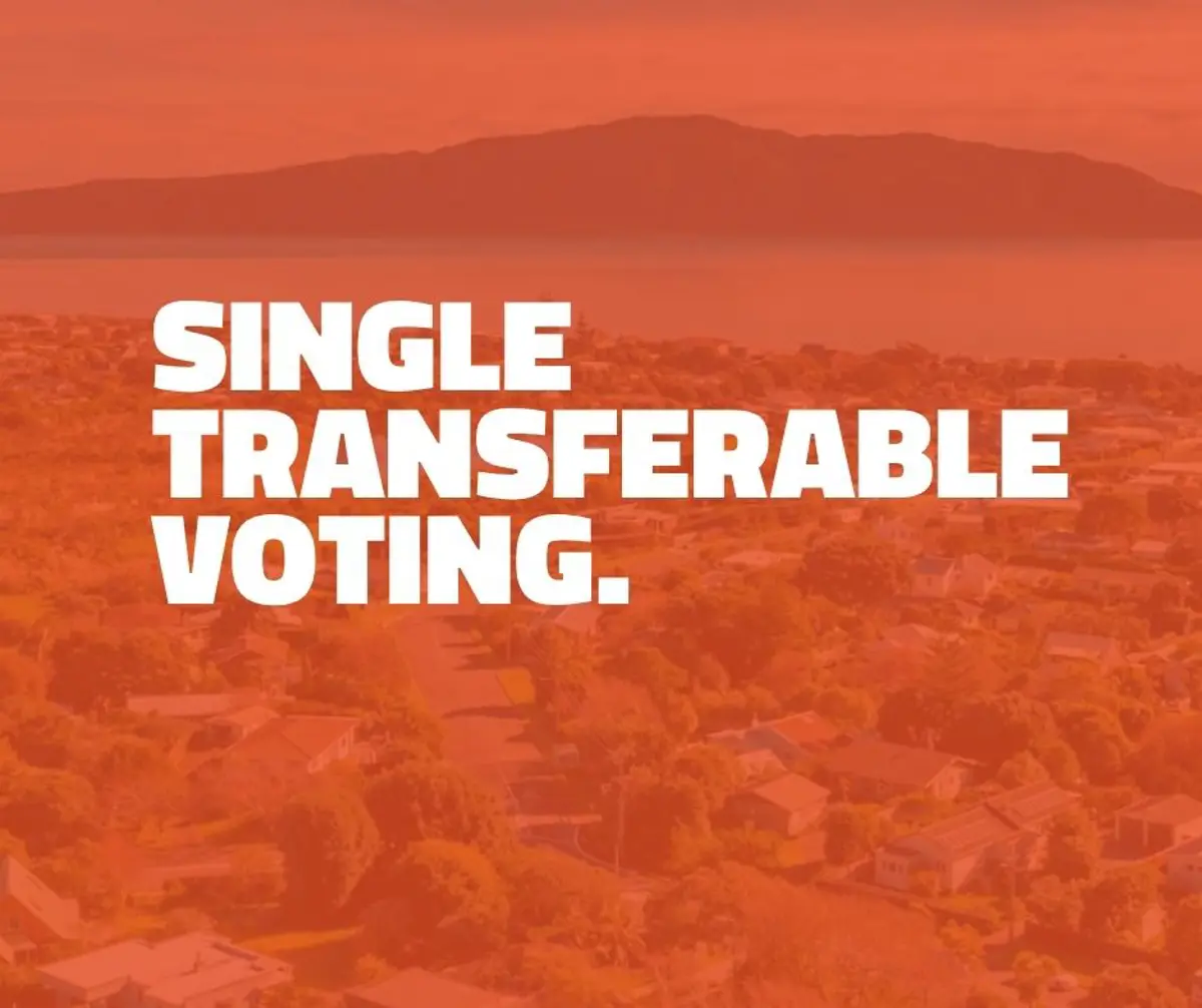 Orange-tinted aerial view of a coastal residential area with hills and water in the background. Large white text over the image reads: “SINGLE TRANSFERABLE VOTING.”. The design appears to be part of a local elections information campaign.