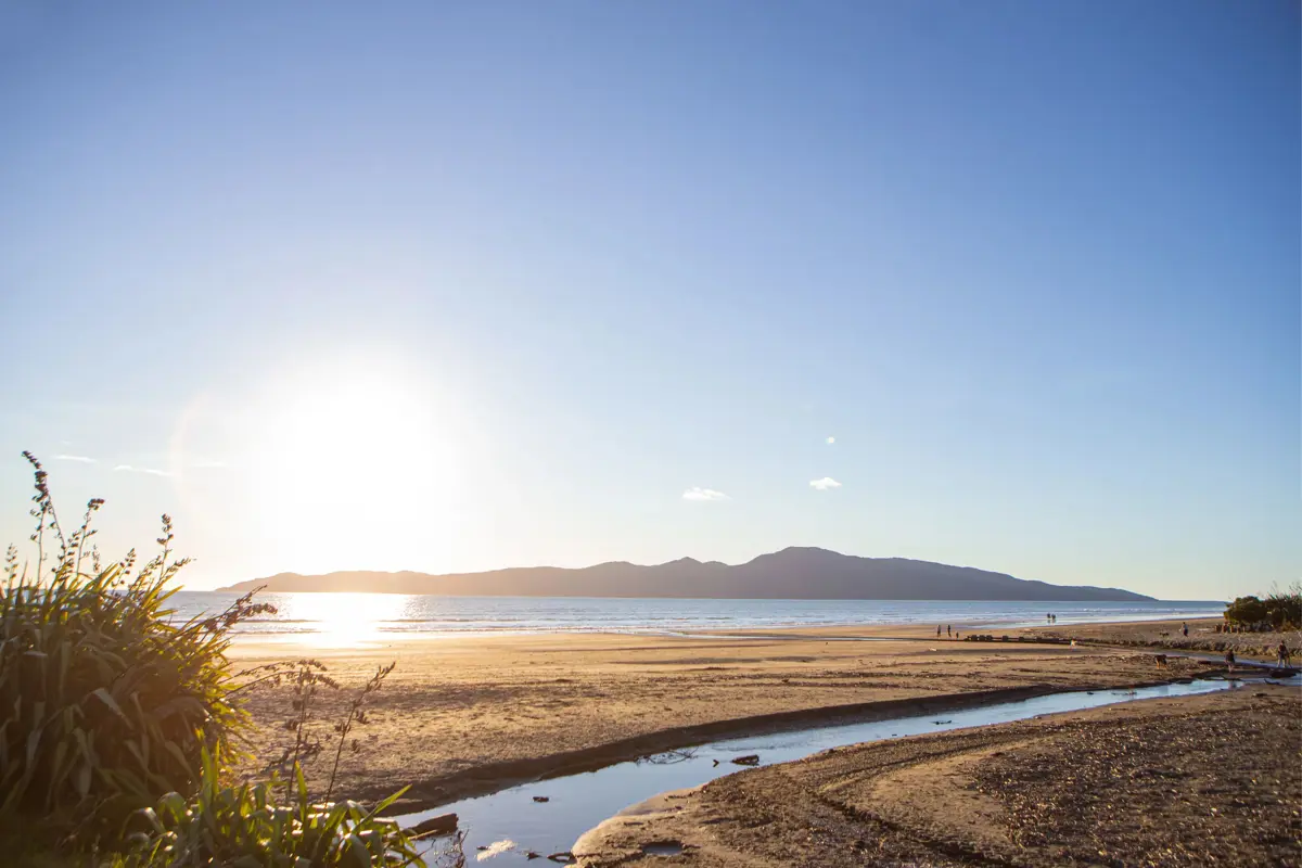 Beach stream with Kāpiti island in the background. Image taken from raumati beach and sun is setting high