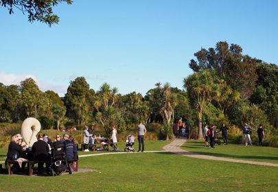 Image showing people sitting and walking in the sun at Ngā Manu nature reserve