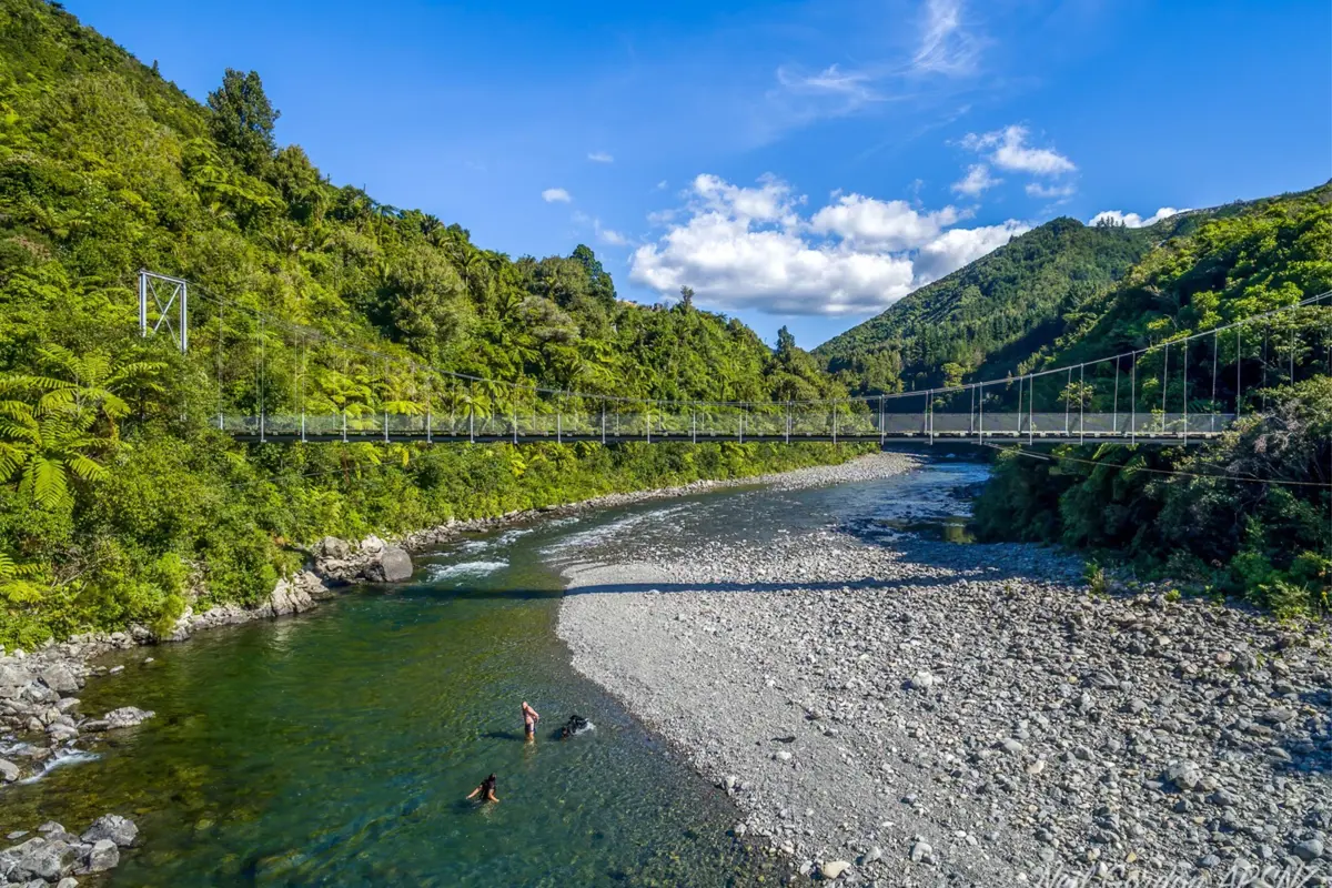 River bed with a bridge in the background and trees