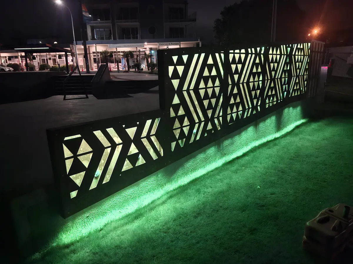 Waharua by artist Kereama Taepa lit green at night.