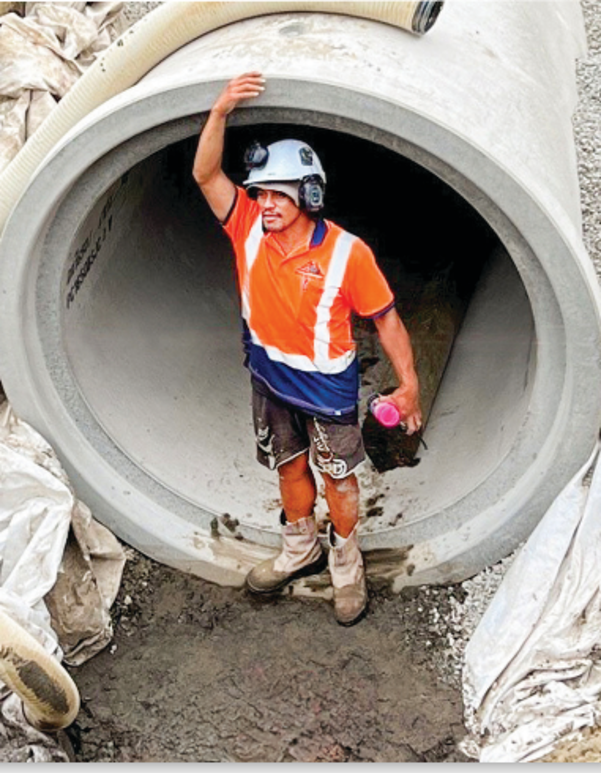 Worker In Hard Hat Standing In Pipe