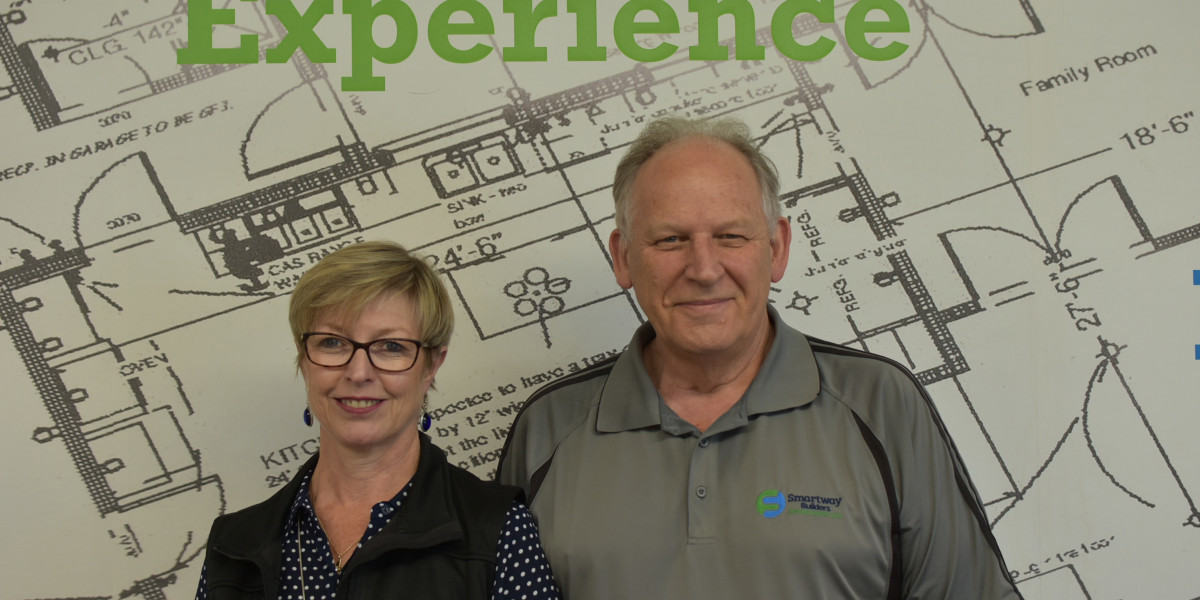 Howard and Ann standing in front of building plans