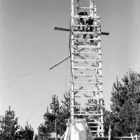 Construction of the statue of Our Lady Lourdes in 1958, showing a wooden structure, and the statue's head about to be hoisted into place. thumbnail