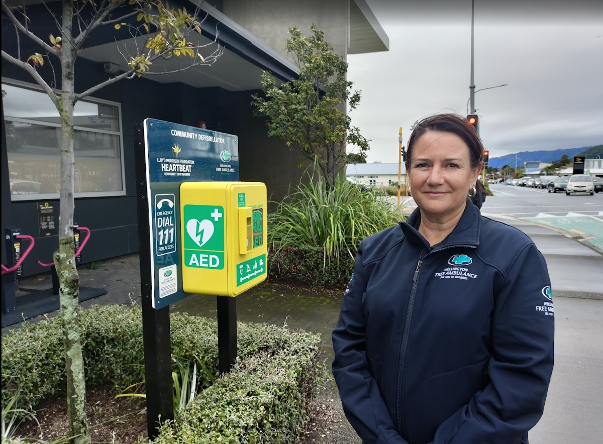 Manager of Wellington Free’s Heartbeat AED programme Rachel Evans with the recently relocated AED on Rimu Rd, Paraparaumu