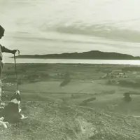 Barry Hadfield with dogs Flash and Blaize, looking over Paraparaumu towards Kāpiti Island. thumbnail