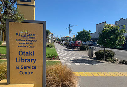 Image showing the sign of the Ōtaki Library and service centre, and a view down Ōtaki's main road