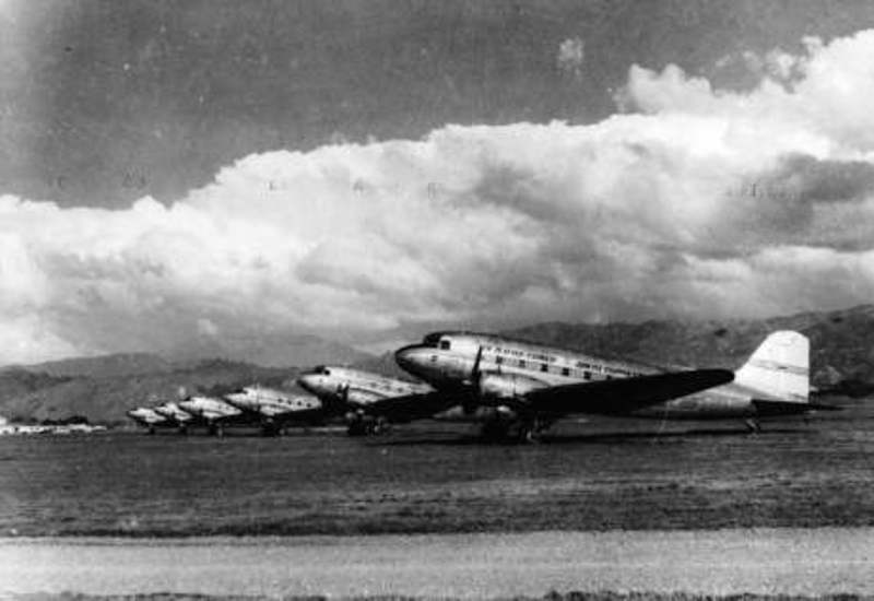 Six DC3s tied down overnight to prevent wind damage, Paraparaumu Airport 1953. HP1485, Vaughn Collection, Kāpiti Coast District Libraries.