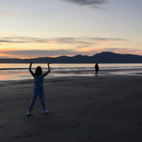 People playing on Paraparaumu Beach at dusk, with Kāpiti Island in the background. thumbnail